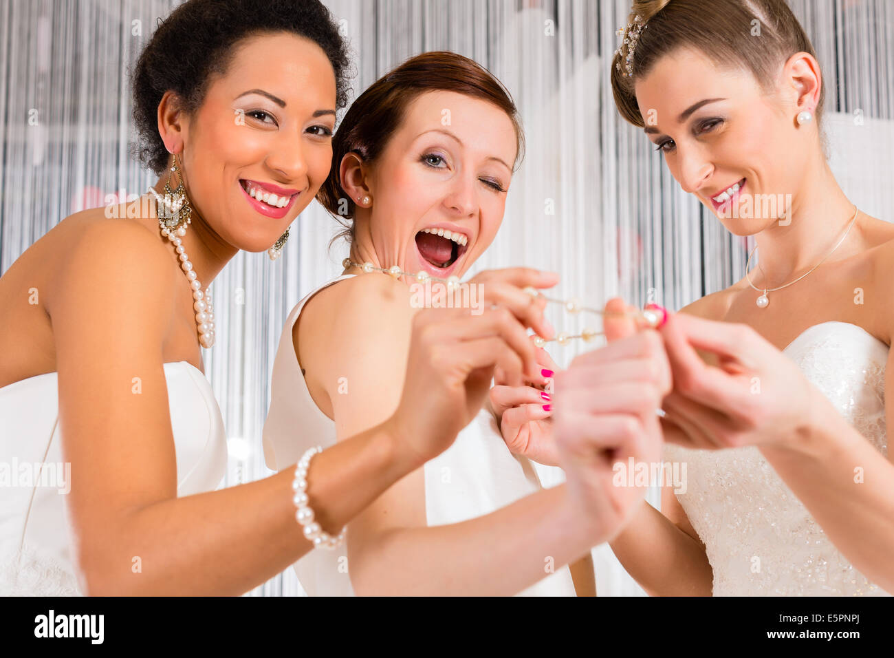 Women having fun while bridal gown fitting in wedding fashion store Stock Photo