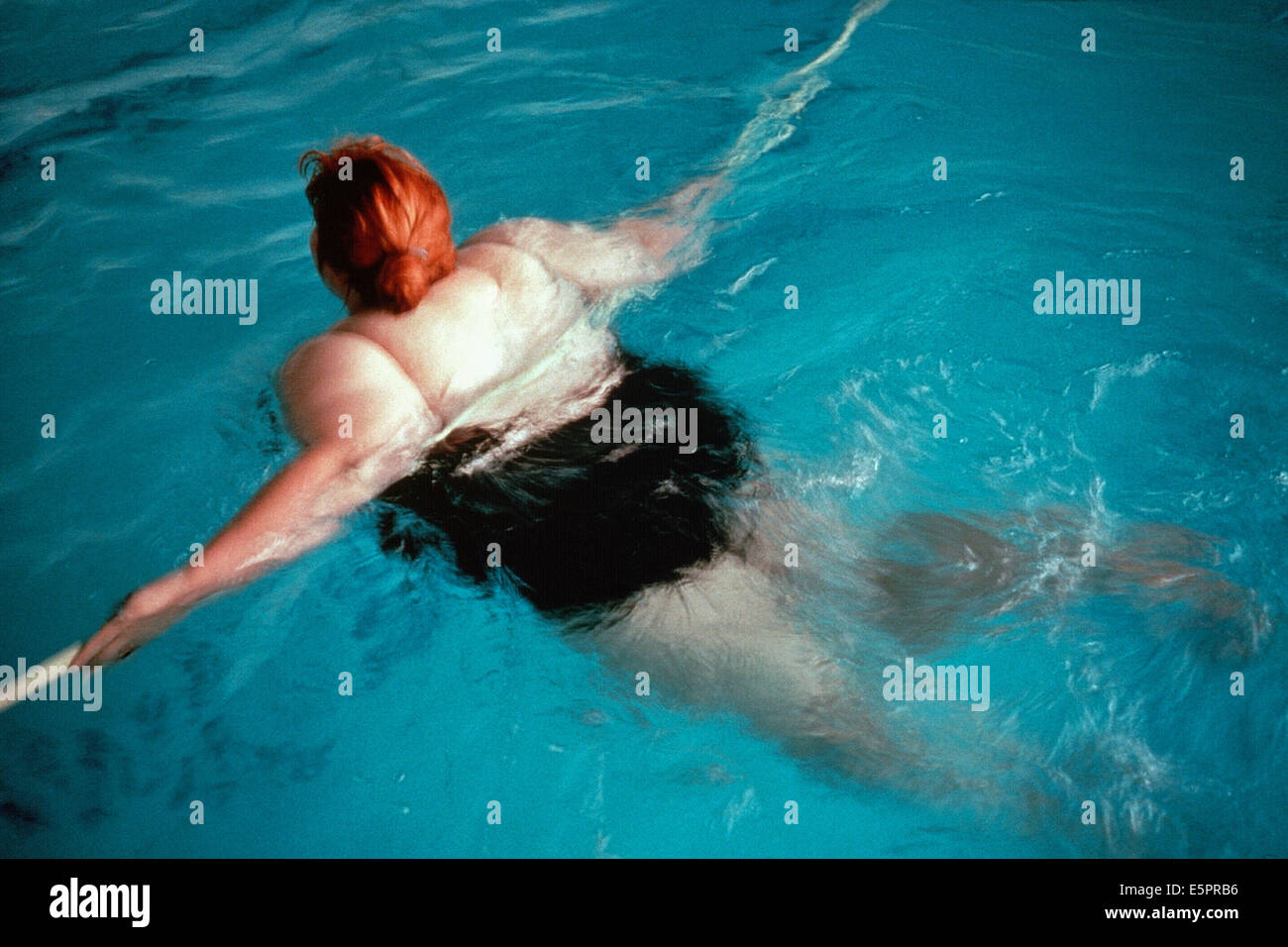 Obese woman swimming. Stock Photo