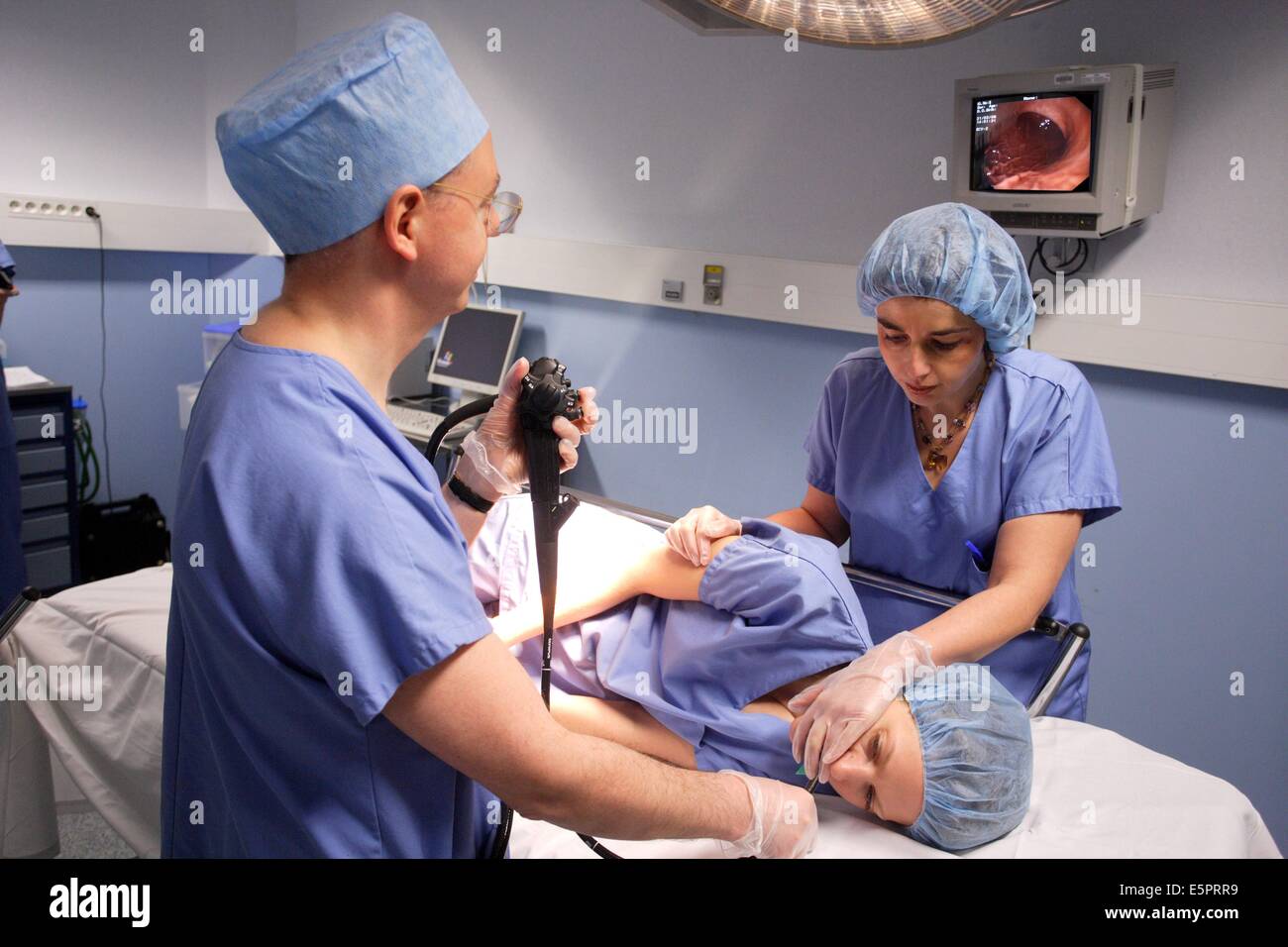 Gastroenterologist performing a gastrointestinal fiberoptic endoscopy, A flexible fibre-optic endoscope is introduced through Stock Photo