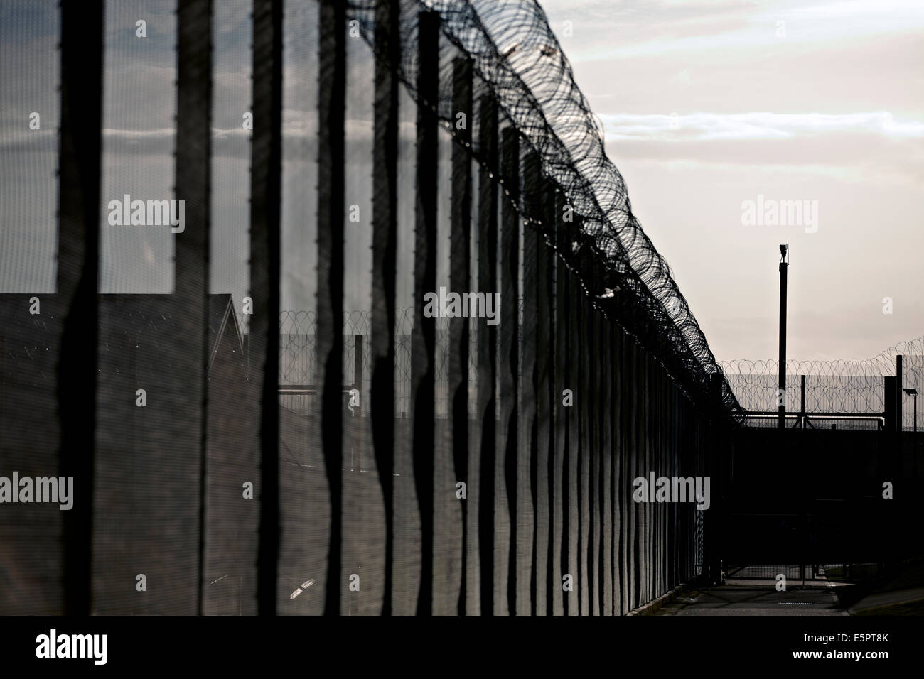Security fencing, razor wire and CCTV cameras around the perimeter of a UK prison. Stock Photo