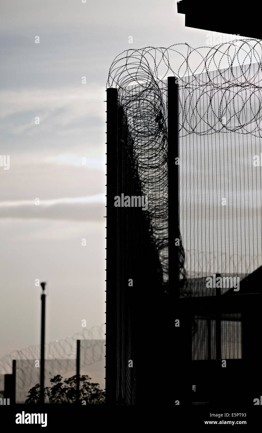 Security fencing, razor wire and CCTV cameras around the perimeter of a ...