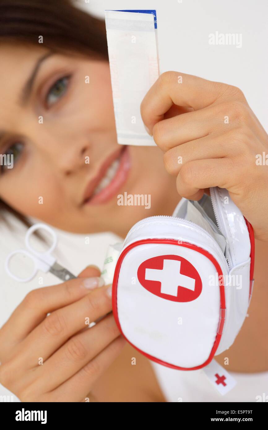 Woman preparing a medical kit containing first aid supplies before leaving on holidays. Stock Photo