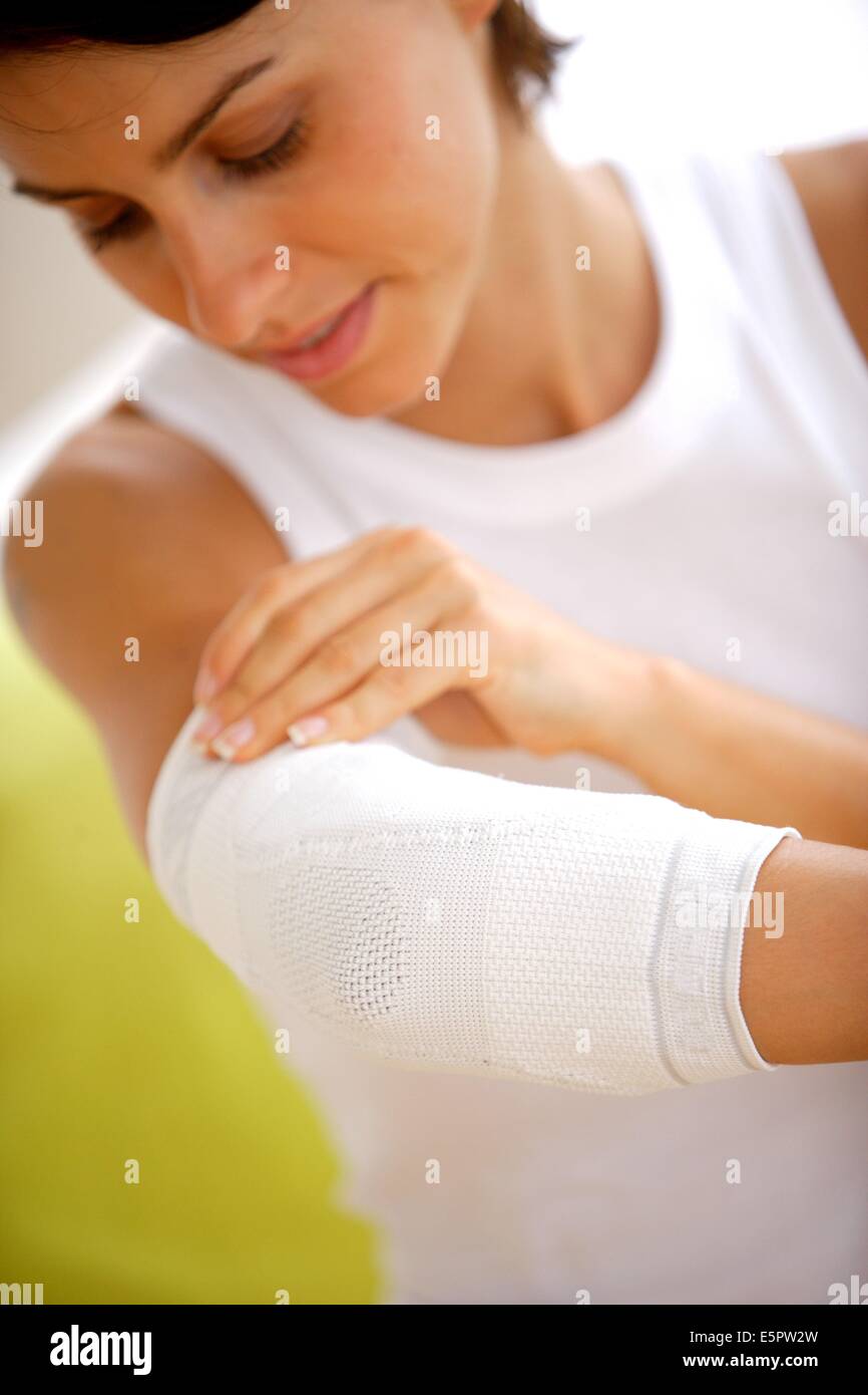 Woman wearing an elbow holder. Stock Photo