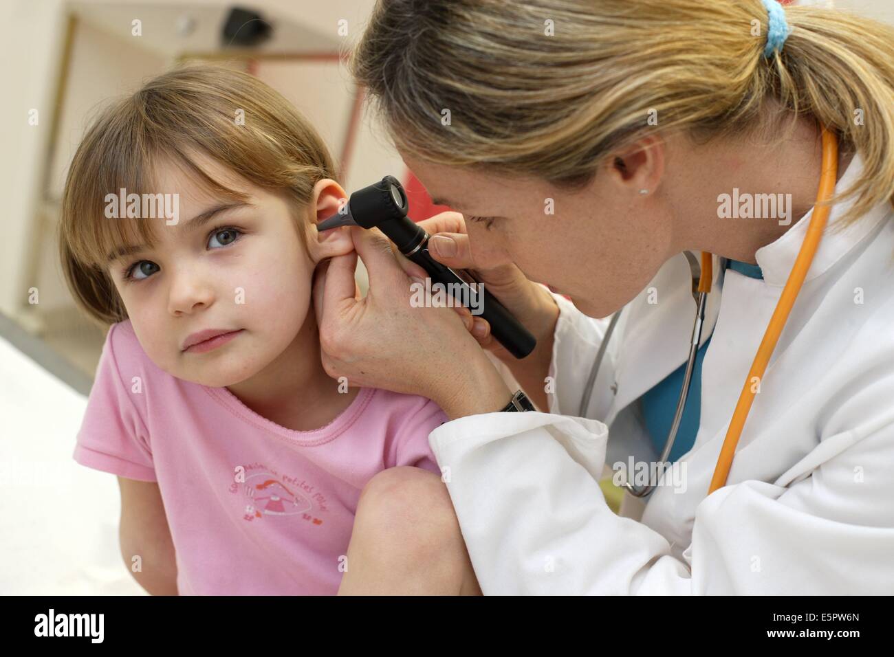 Pediatrician examining the ears of a 4yearold child with an otoscope