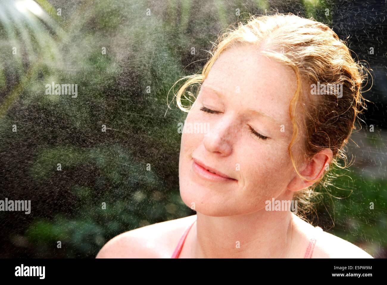 Woman spraying water on her face Stock Photo Alamy
