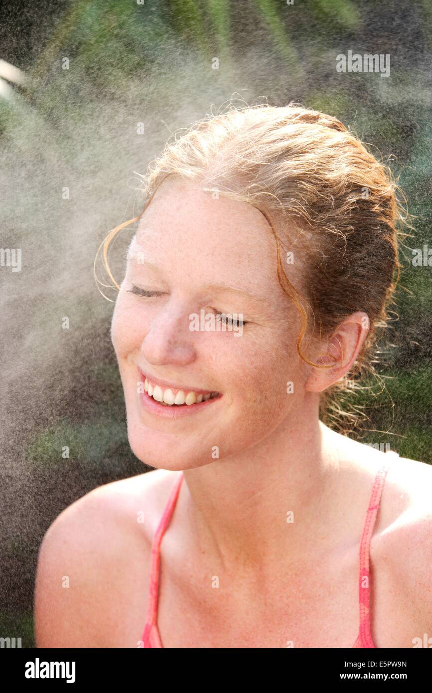 Woman spraying water on her face Stock Photo Alamy