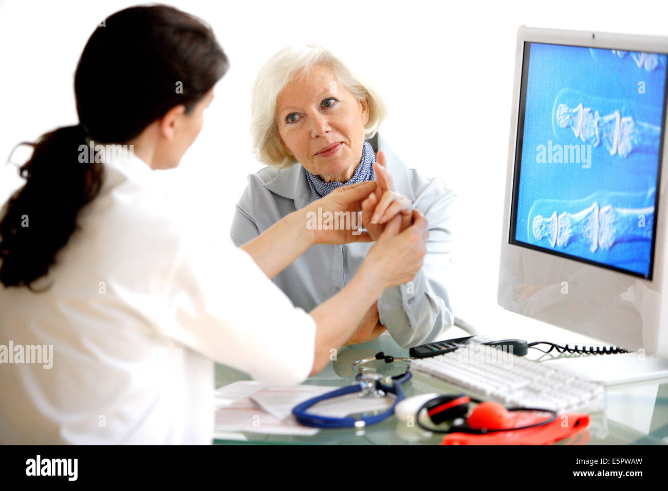 Doctor examining the hand of a female patient. Stock Photo