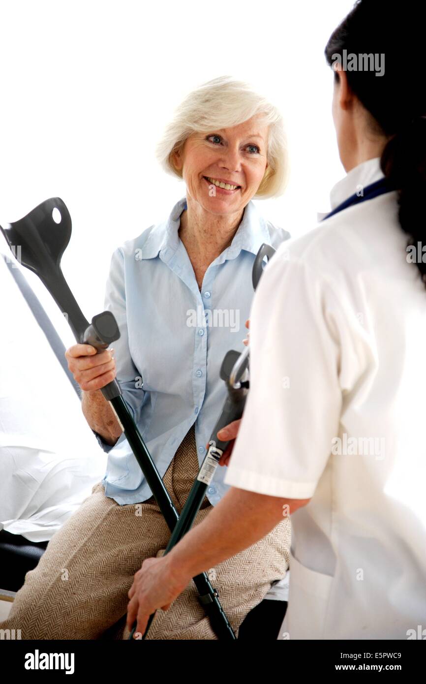 Doctor talking elderly woman crutches hi-res stock photography and ...