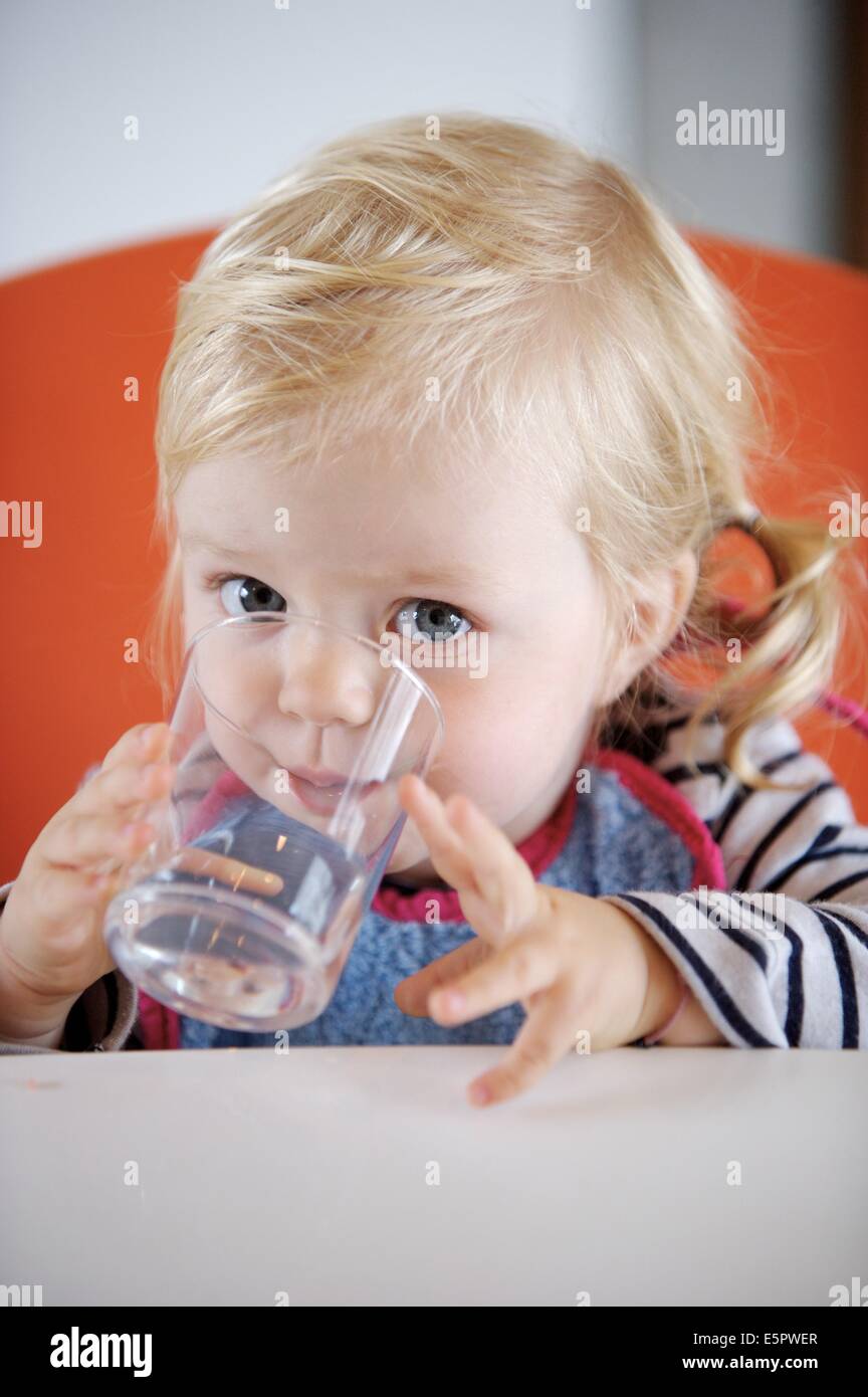 18 month old baby girl drinking a glass of water Stock Photo Alamy