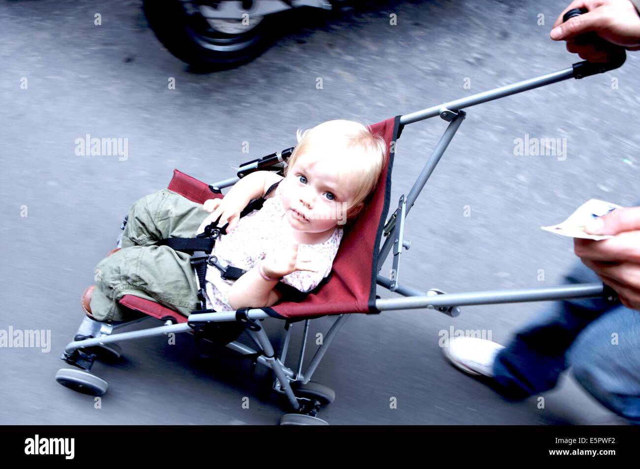 18 months old baby girl in a baby stroller. Stock Photo