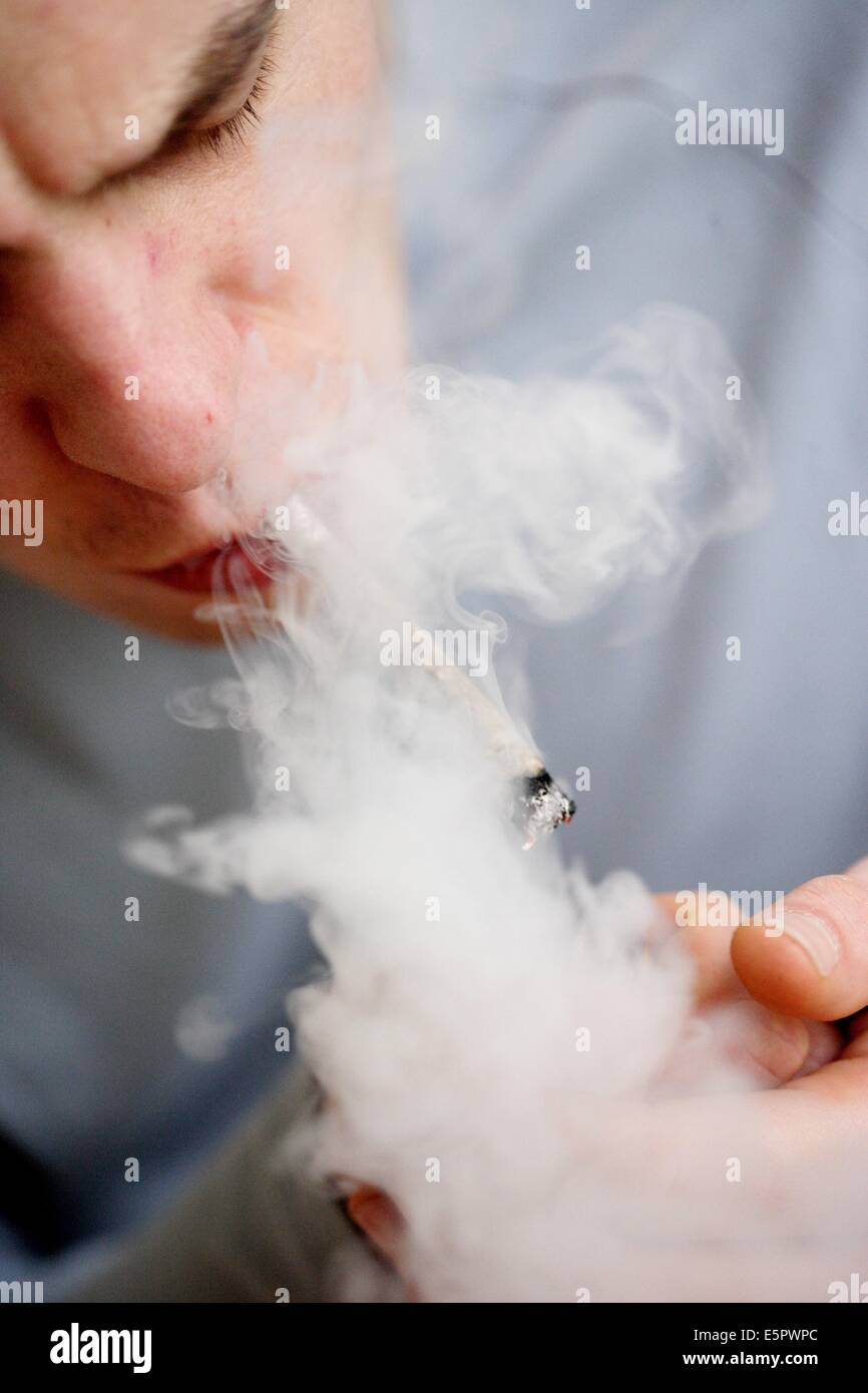 Man smoking marijuana or hashish cigarette. Stock Photo