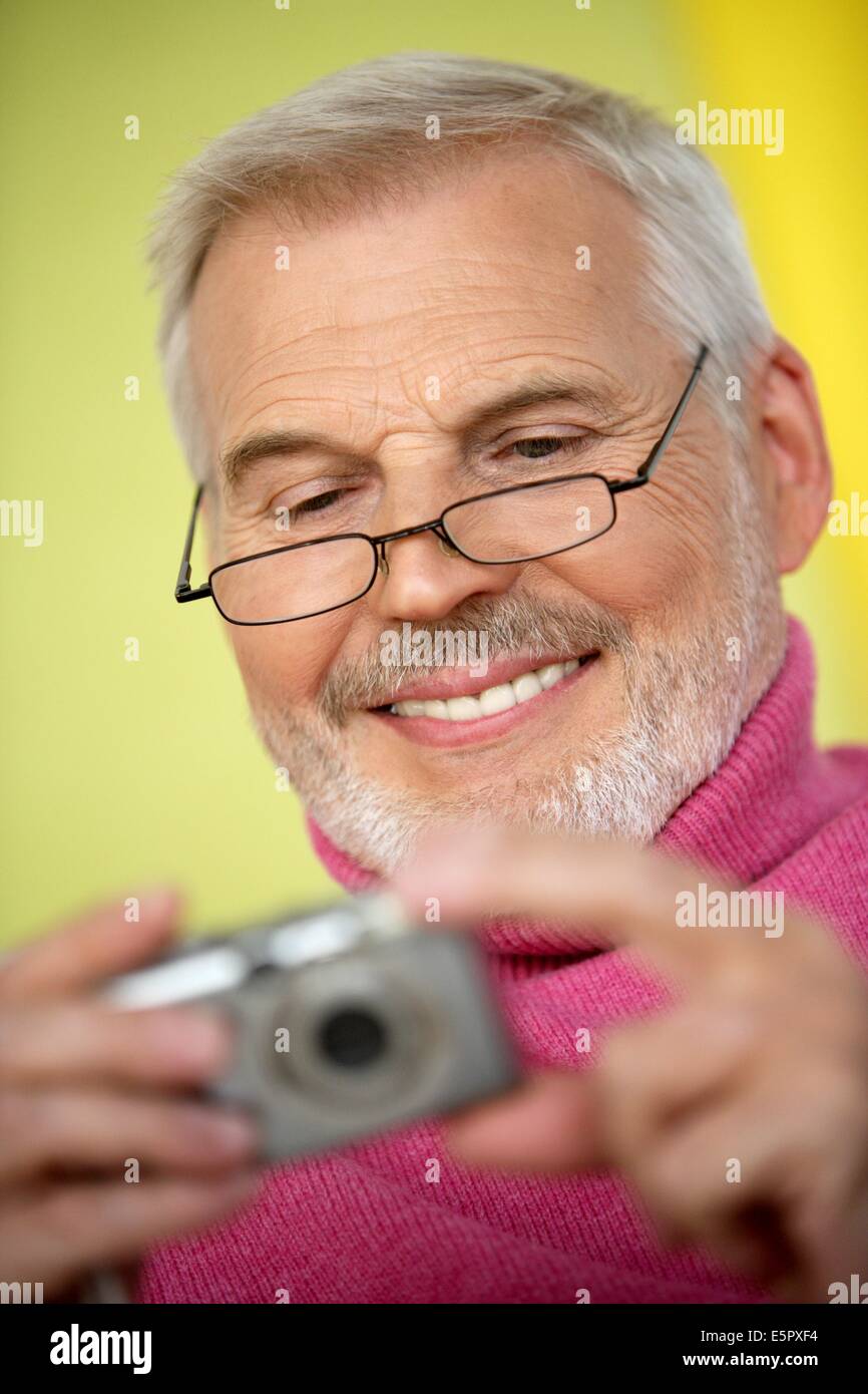 Man watching photos on a digital camera. Stock Photo