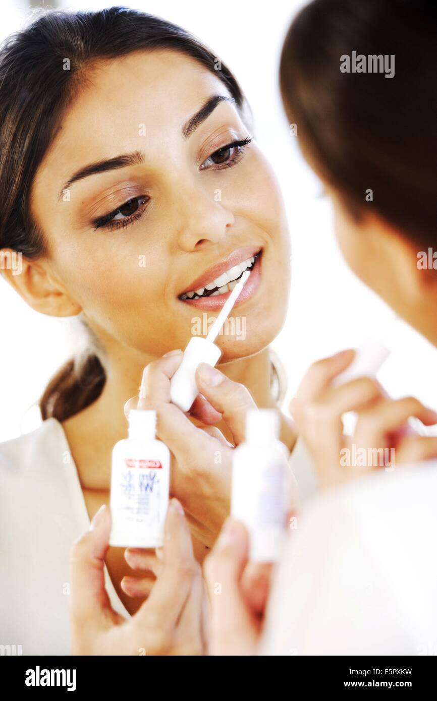 Woman applying a bleaching gel on her teeth Stock Photo Alamy