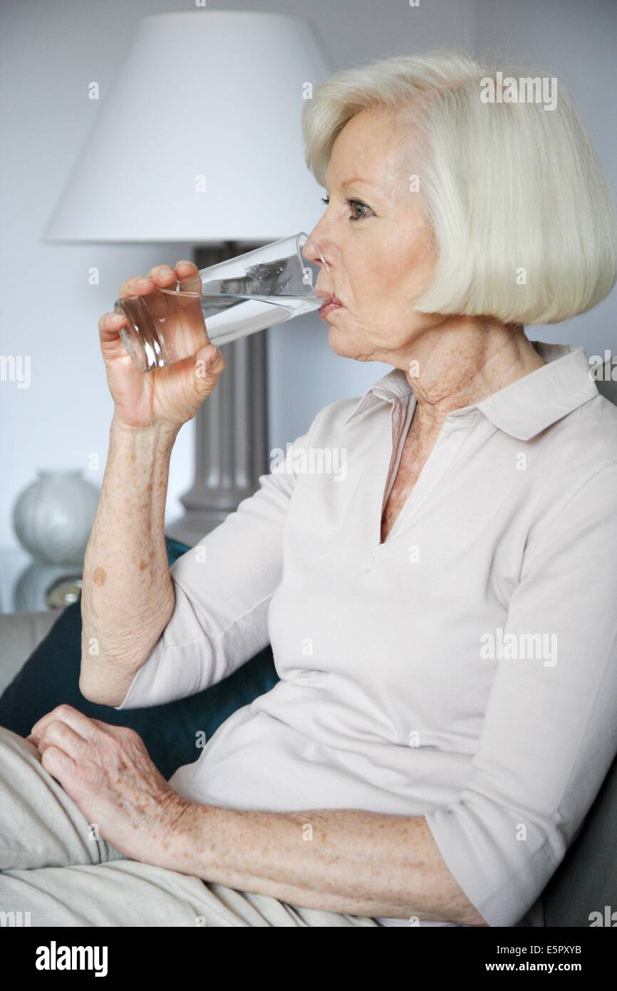 Elderly woman drinking a glass of water Stock Photo Alamy