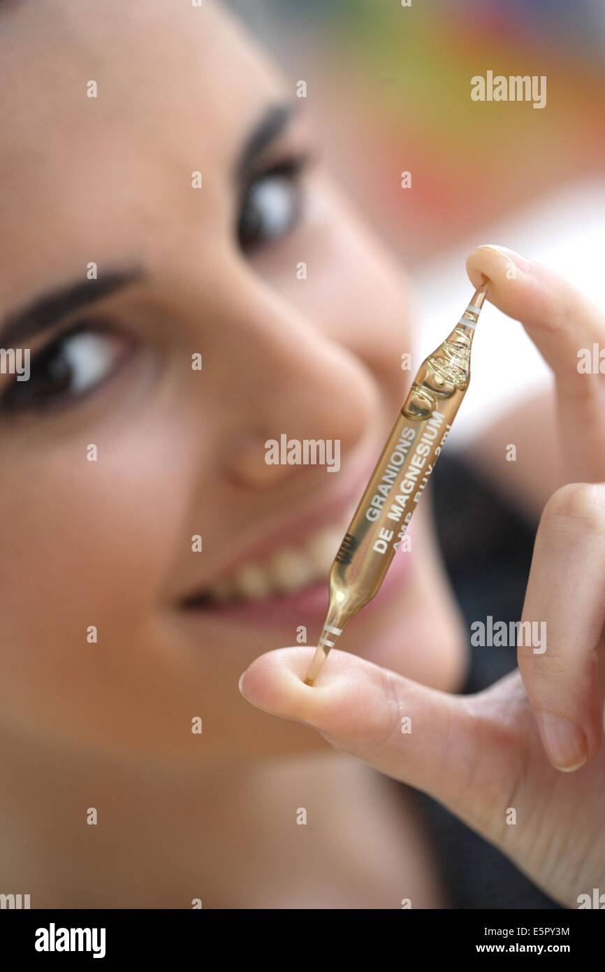 Woman holding a glass ampoule of trace elements. Stock Photo