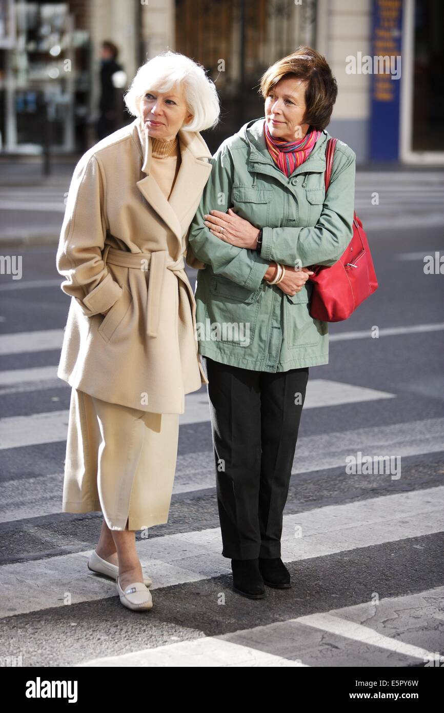 Woman helping elderly woman crossing the street. Stock Photo