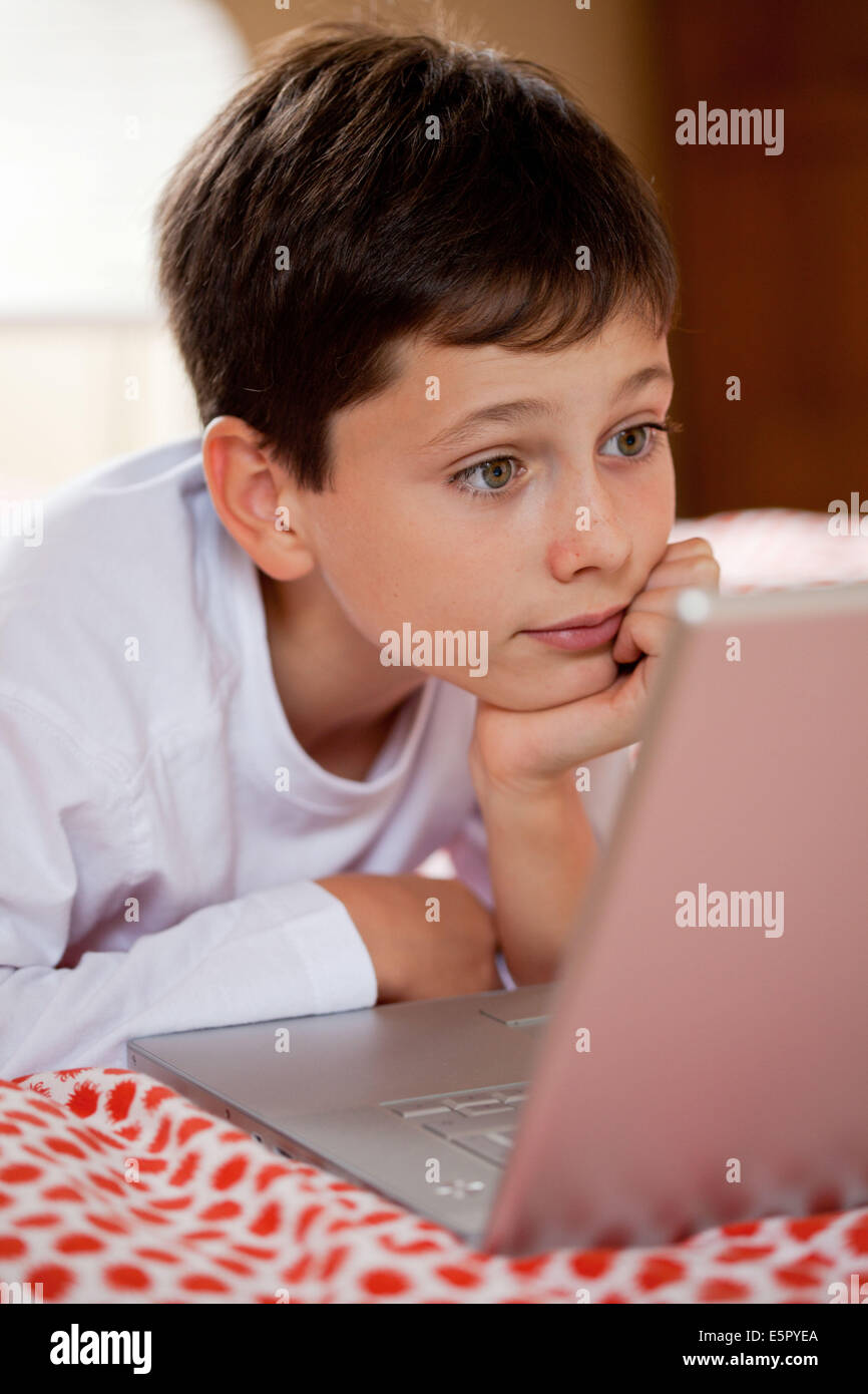 10 year old boy using laptop computer. Stock Photo