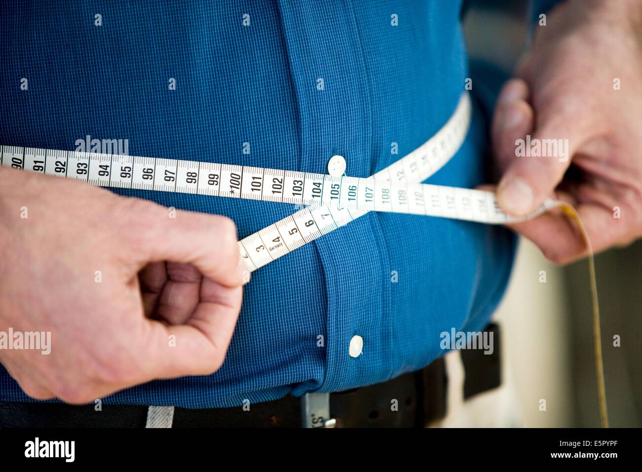 Man measuring his waist with tape measure Stock Photo Alamy