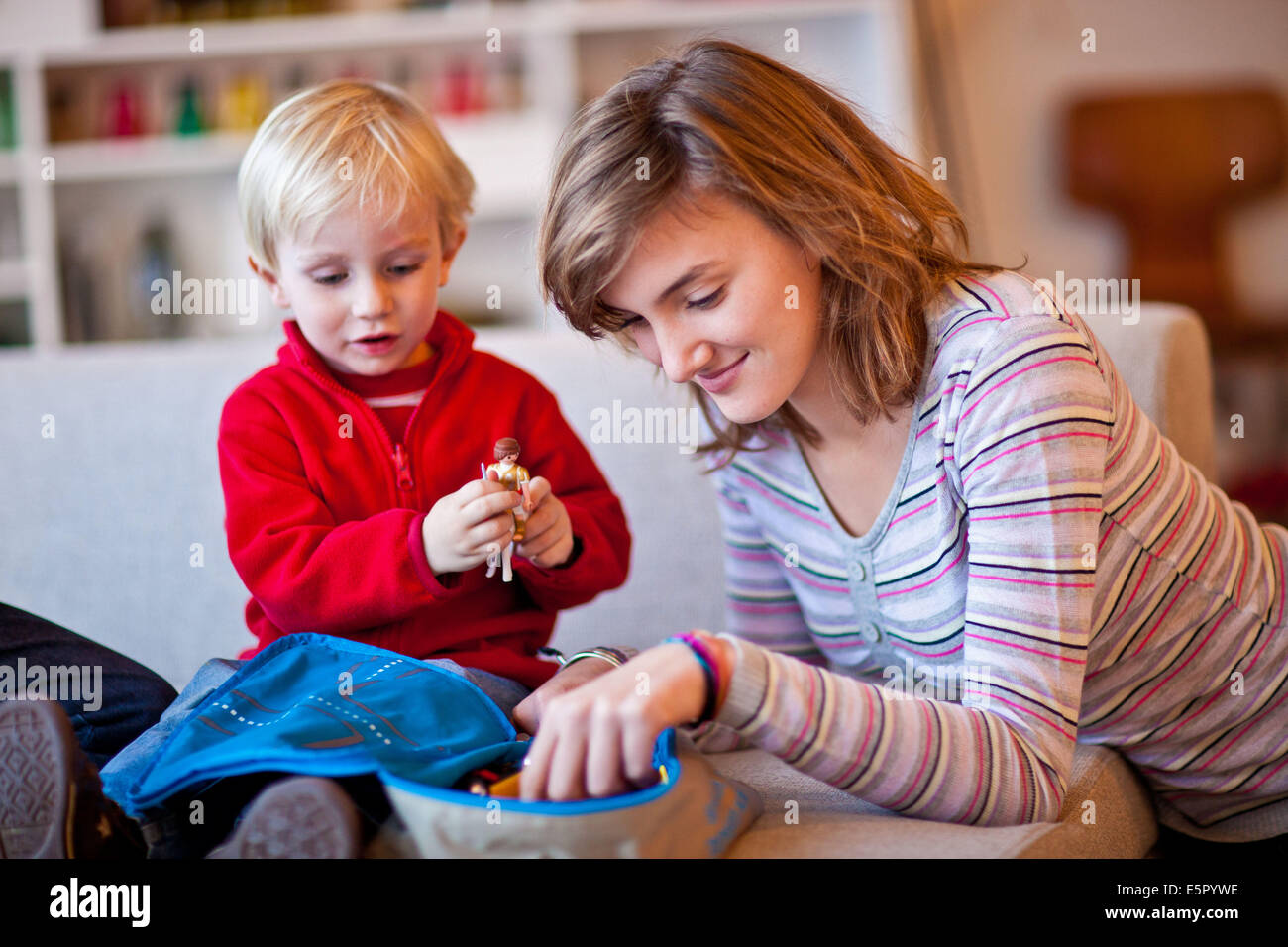 Teenage girl and 3-year-old boy playing with figurines. Stock Photo