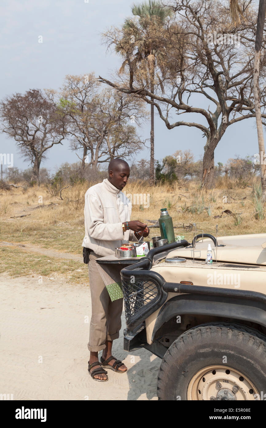 Local safari tour guide driver prepares open air breakfast for the ...