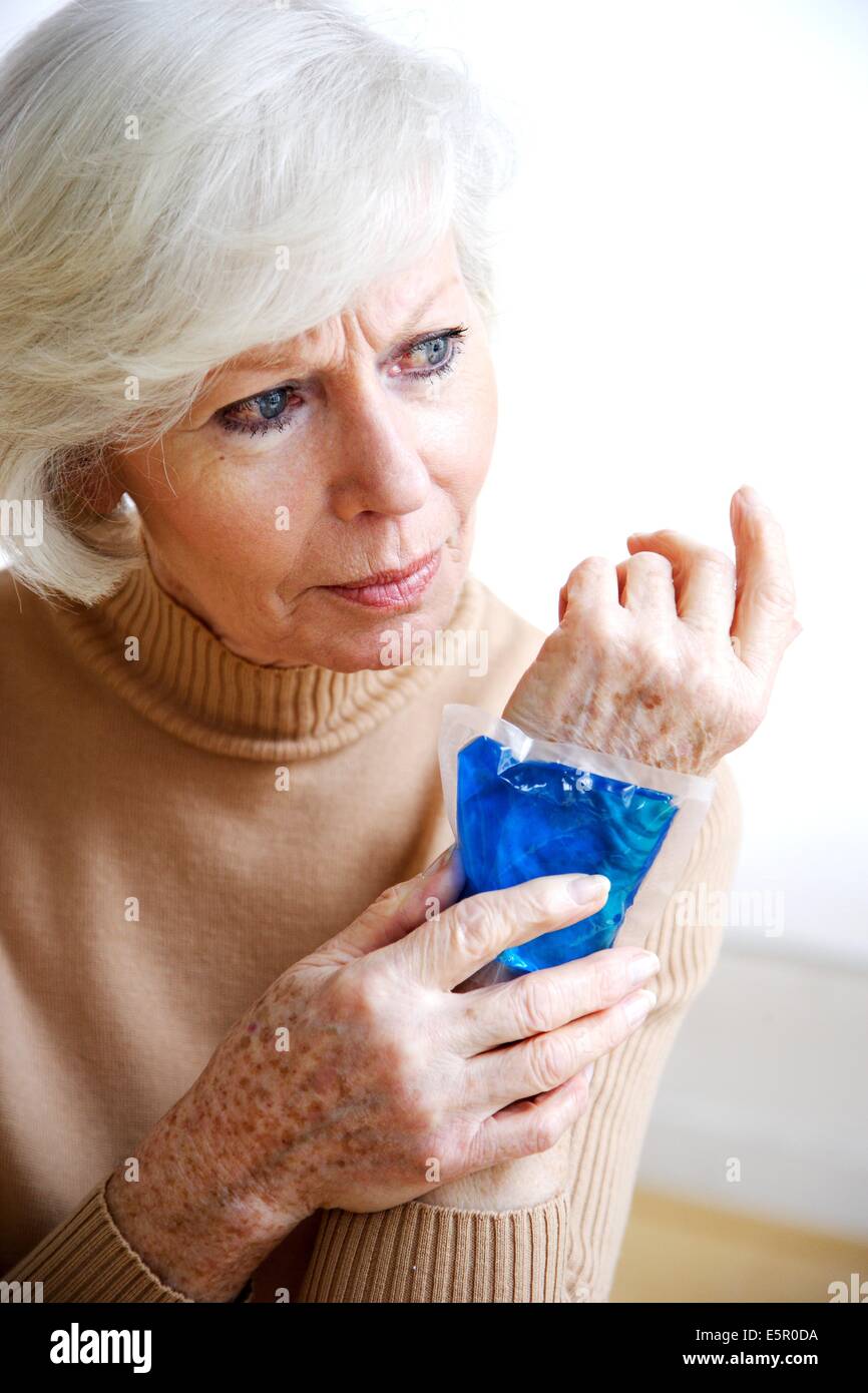 Woman using a hotcold gel pack treatment to releive pain Stock Photo