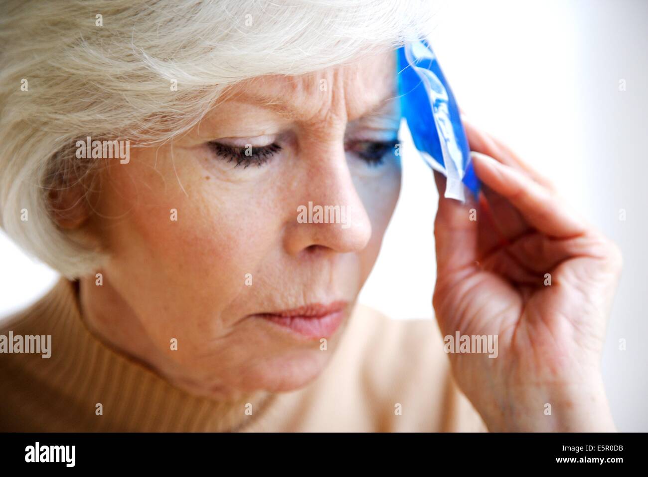 Woman using a hotcold gel pack treatment to releive pain Stock Photo