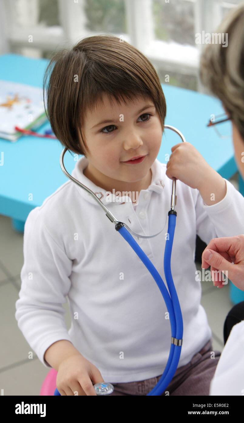 Therapeutic games : 5 year old girl playing with stethoscope. Stock Photo