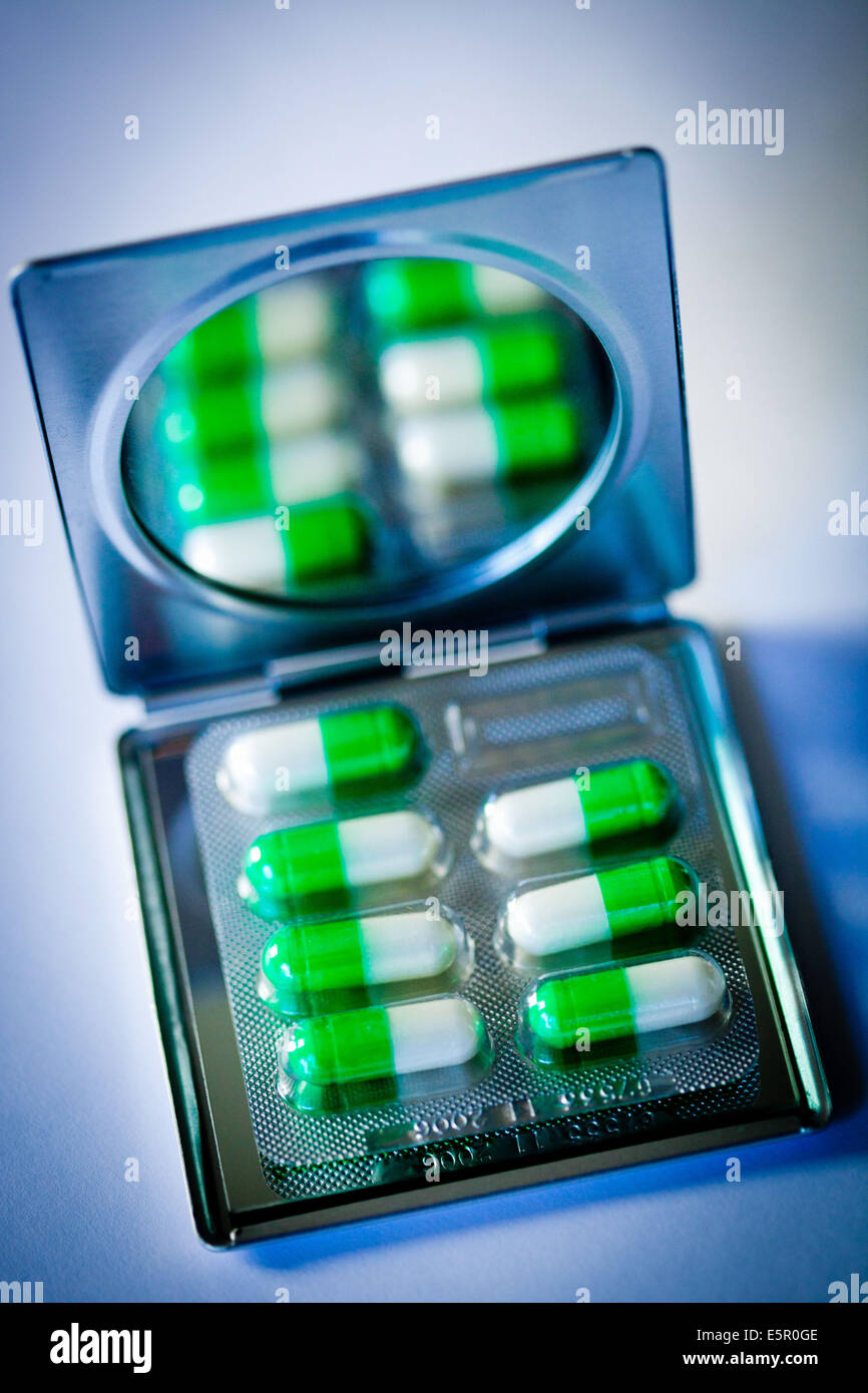Drug capsules on mirror. Stock Photo