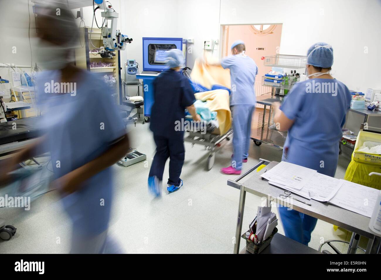 Surgical staff bringing patient in operating room. Stock Photo