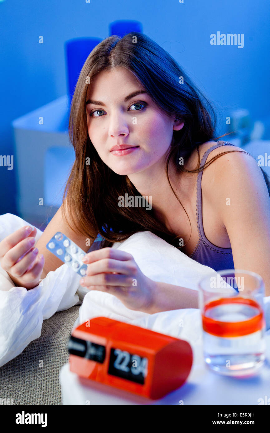 Woman taking medication in bed Stock Photo Alamy