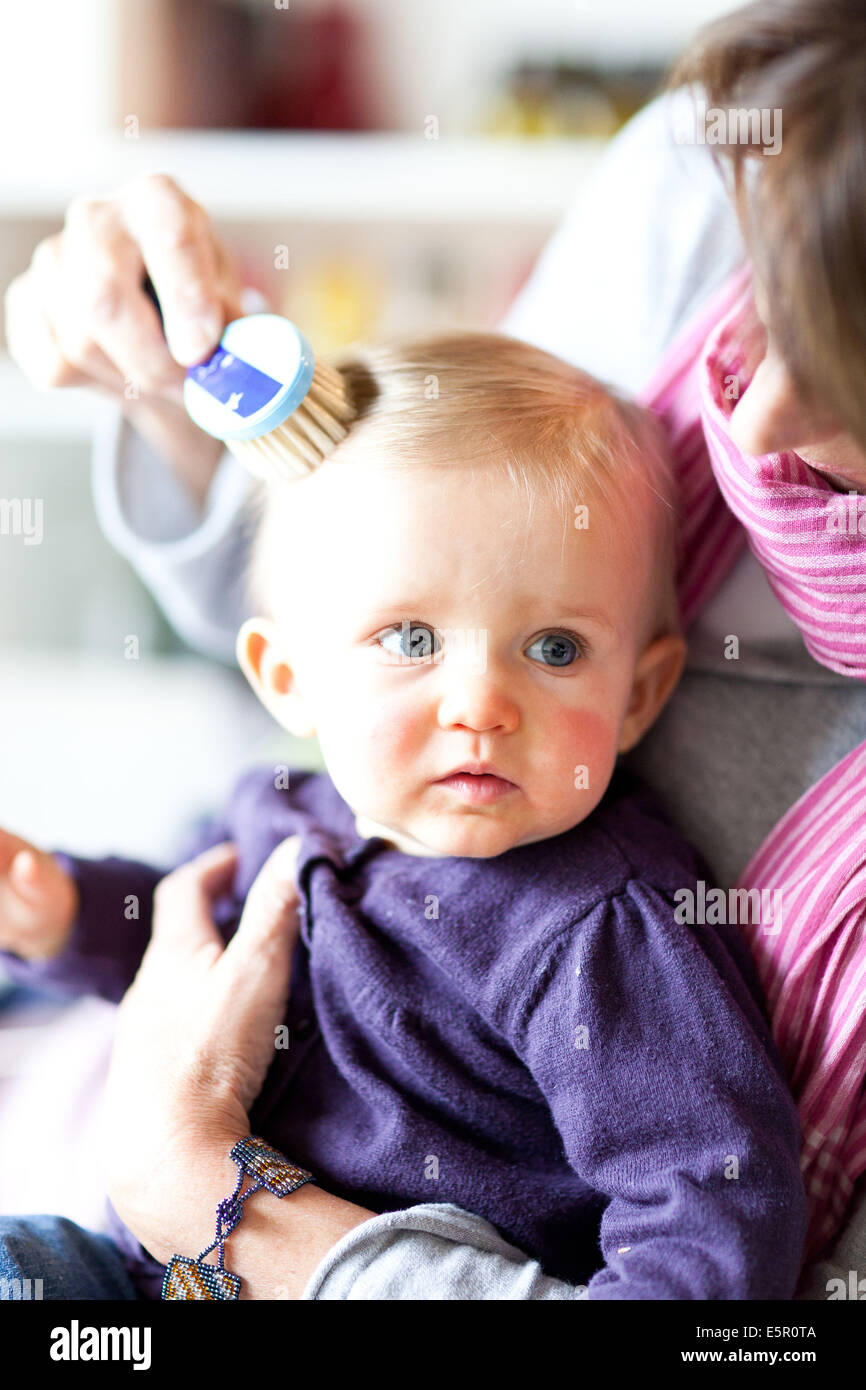 Mother brushing the hair of her 10monthold baby Stock Photo Alamy