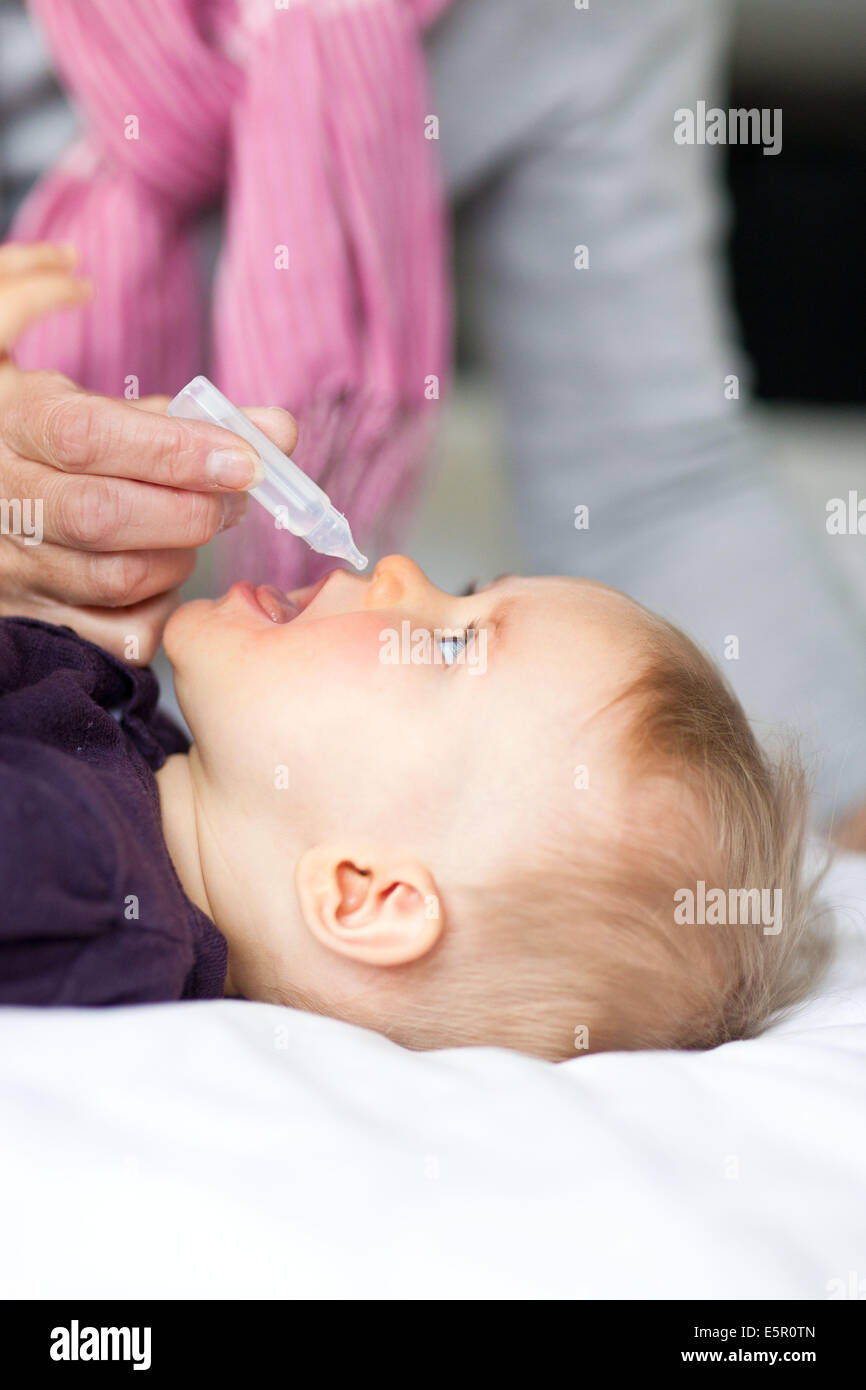 10 month old baby having his nose cleared with physiological saline