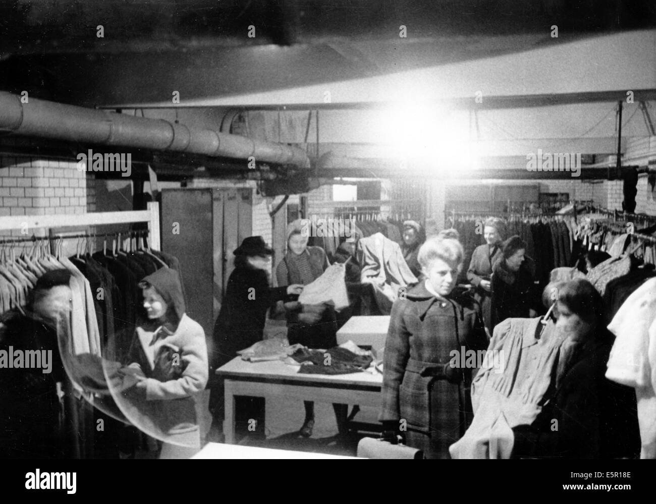 The picture from a Nazi news report shows women shopping for clothes in the basement of a boutique after an air raid in Berlin, Germany, October 1944. The original text on the back of the picture reads: 'Life in Berlin today. A big Berlin fashion boutique continues with its basement shopping. Just like this store, many others are operating in basements or other parts of their stores that have escaped damage during the bombing terror.' Fotoarchiv für Zeitgeschichte - NO WIRE SERVICE Stock Photo
