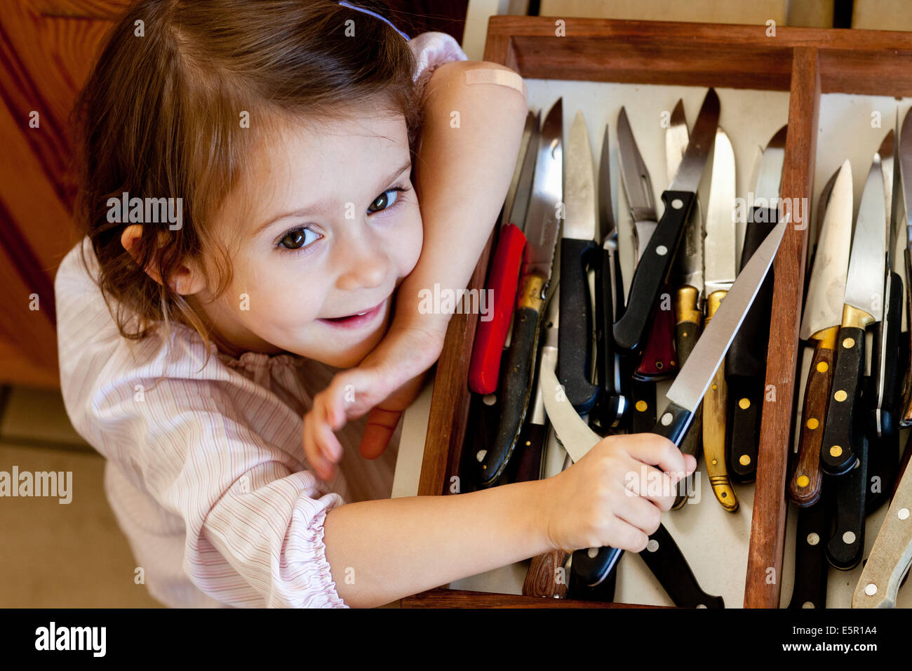 3 year-old girl playing with table knives Stock Photo - Alamy