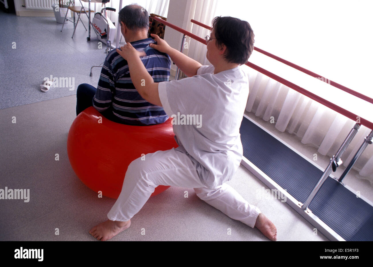 Elderly person doing functional rehabilitation exercises with a physiotherapist, Alzheimer unit of the Geriatrics department, Stock Photo
