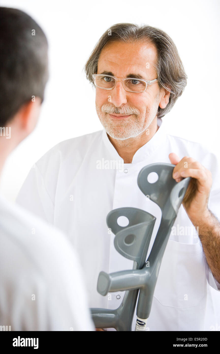 Doctor giving crutches to his patient Stock Photo Alamy