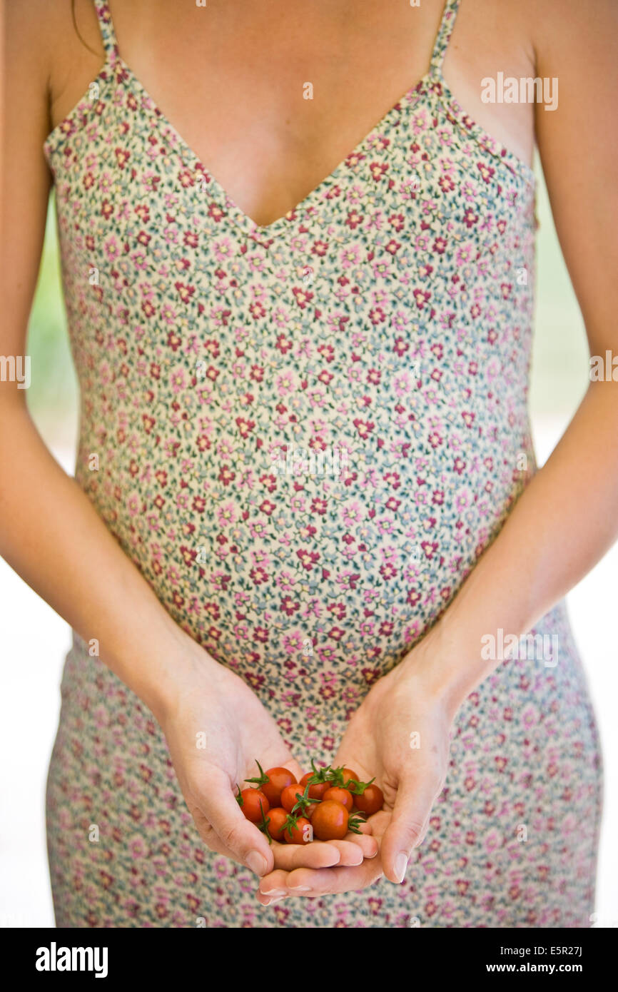 Pregnant woman eating tomatoes Stock Photo Alamy