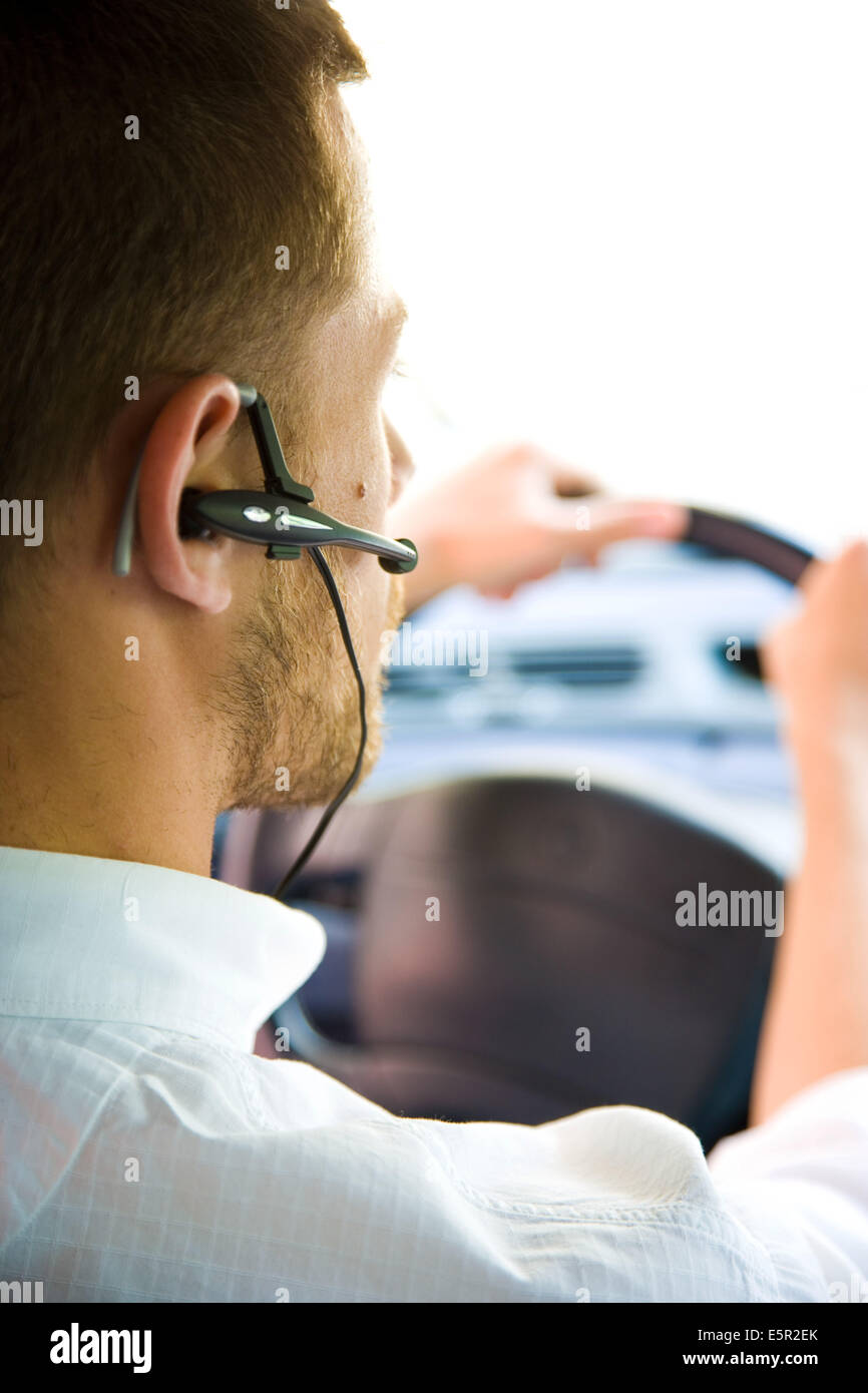 Man using a hands-free kit while driving. Stock Photo