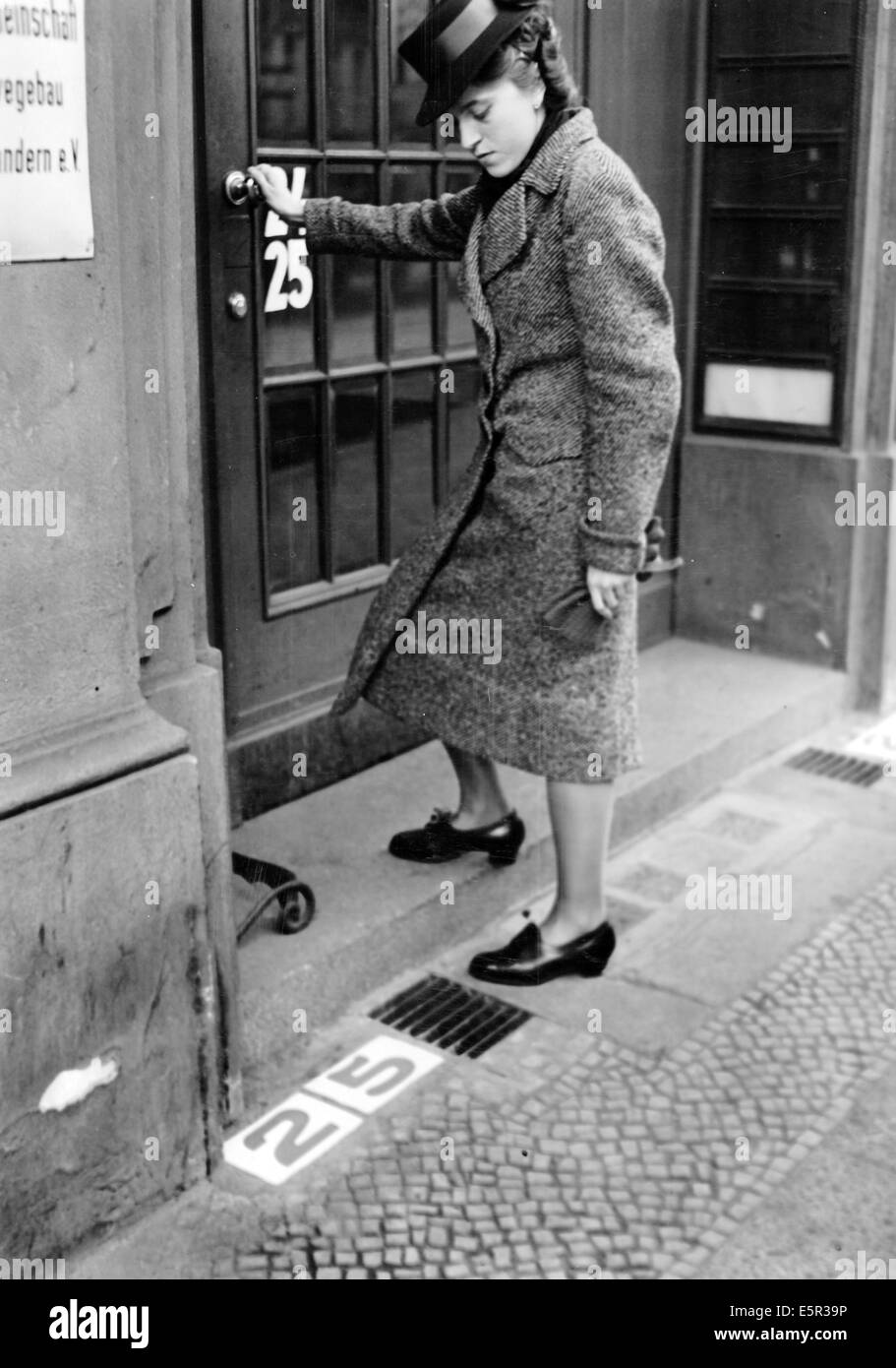 The picture from a Nazi news report shows a woman walking into a building next to the newly introduced address number stones  in Berlin, Germany, November 1940. The original text on the back of the picture reads: 'Here everyone can find the building number. A practical novelty, which is certain to enjoy widespread popularity soon. This number is outside of the department of 'Steine und Erden' (industrial rocks and minerals) in Berlin. The green numbers are set in white stone and makes it easy for even short-sighted people to find the building they are looking for.' Photo: Berliner Verlag / Arc Stock Photo