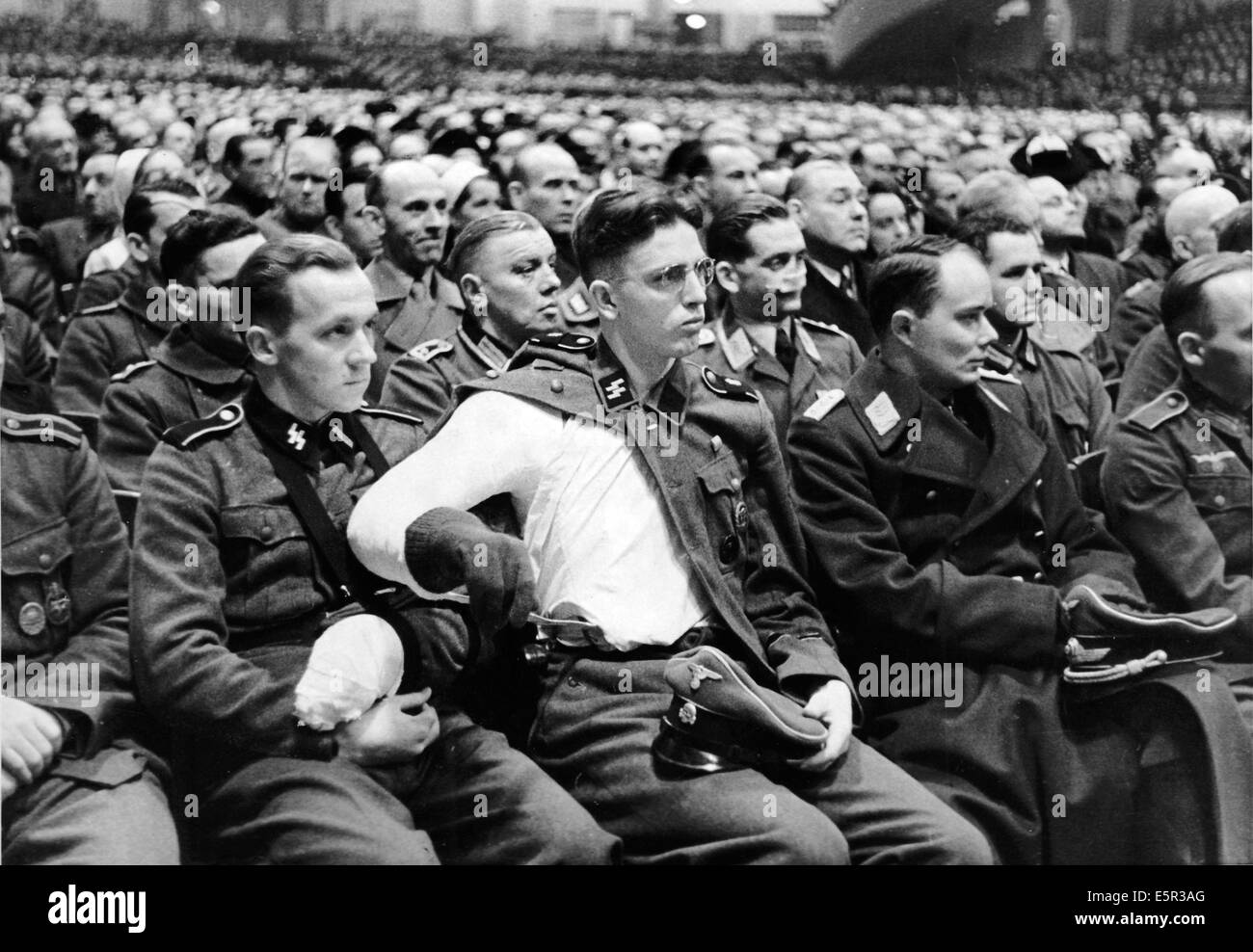 A large group of people listen to the speech by Propaganda Minister Joseph Goebbels, who called for 'total war' at the Sportpalast in Berlin, Germany, 18 February 1943. The original Nazi propaganda text on the back of the picture: 'Grand Sportpalast rally with Reich Minister Dr. Goebbels. In the traditional venue, the Berlin Sportpalast, a large rally was held on 02.18.1943 where Reich Minister Dr. Goebbels gave a speech. The spontaneous consent to the issues discussed by Dr. Goebbels showed the close relationship between the various groups of people from all professions and the Nazi leadershi Stock Photo