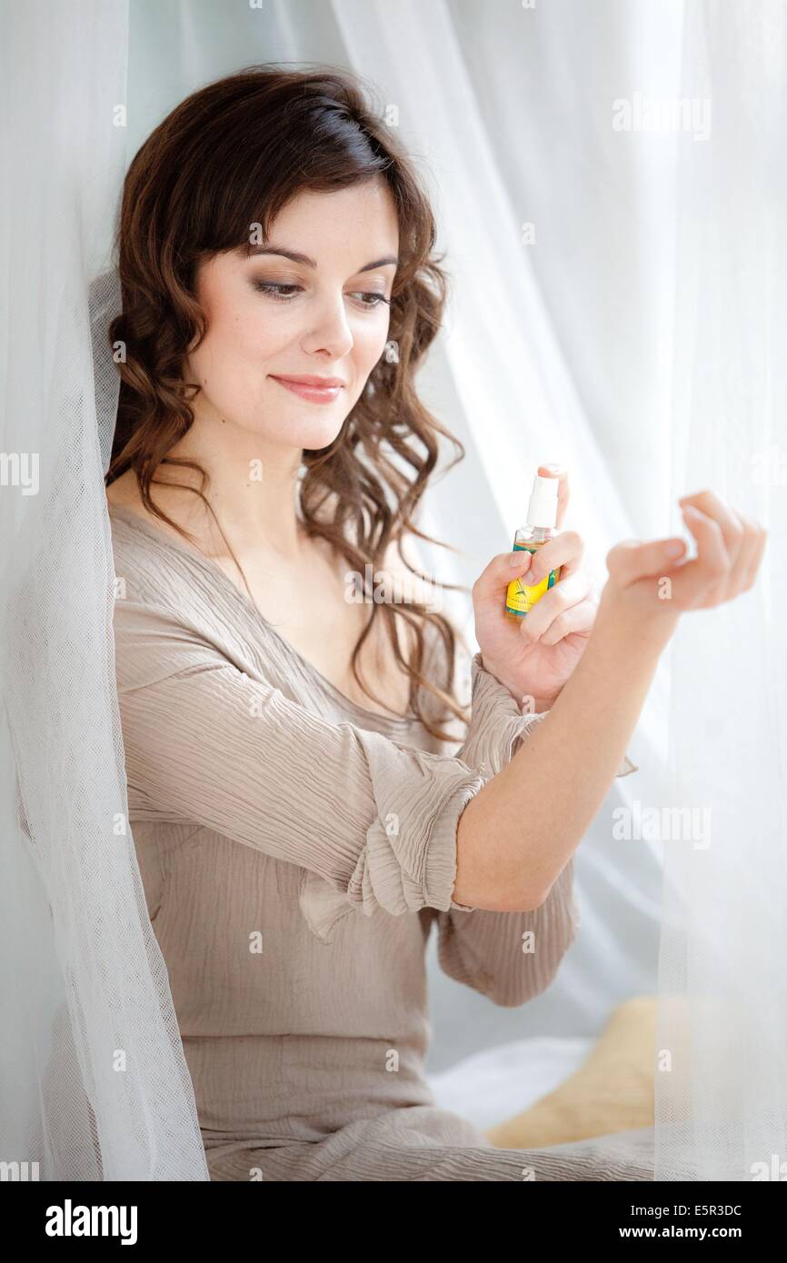Woman applying spray against insect bites and itching on her arm. Stock Photo