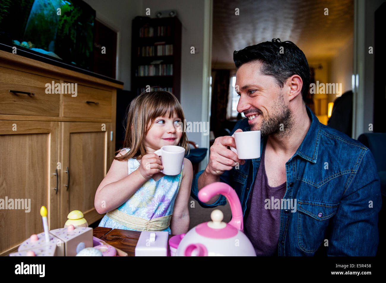 dad and daughter drinking tea and having fun Stock Photo