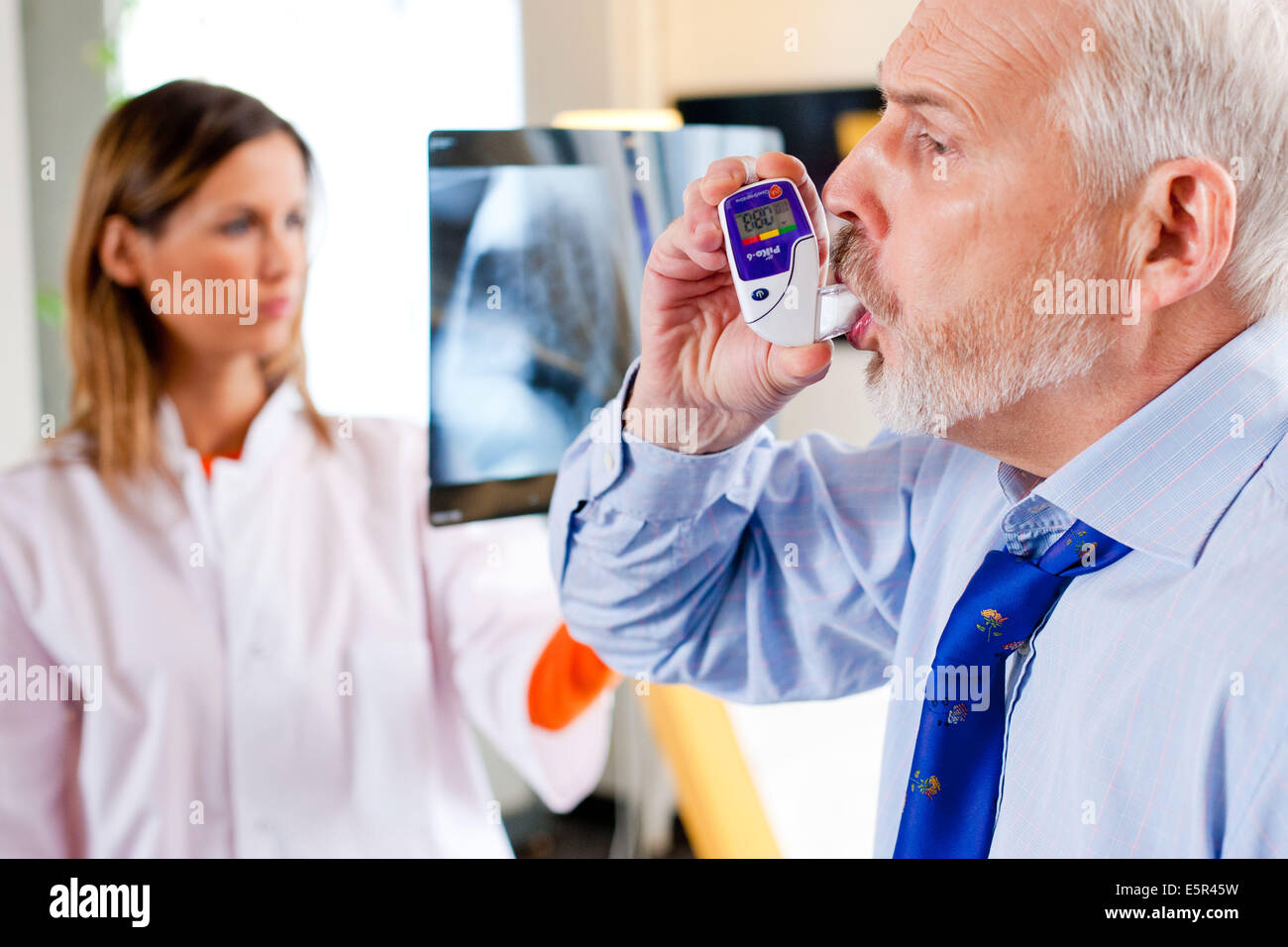 Man using a PIKO6, a digital peak flow meter mesuring the volume of