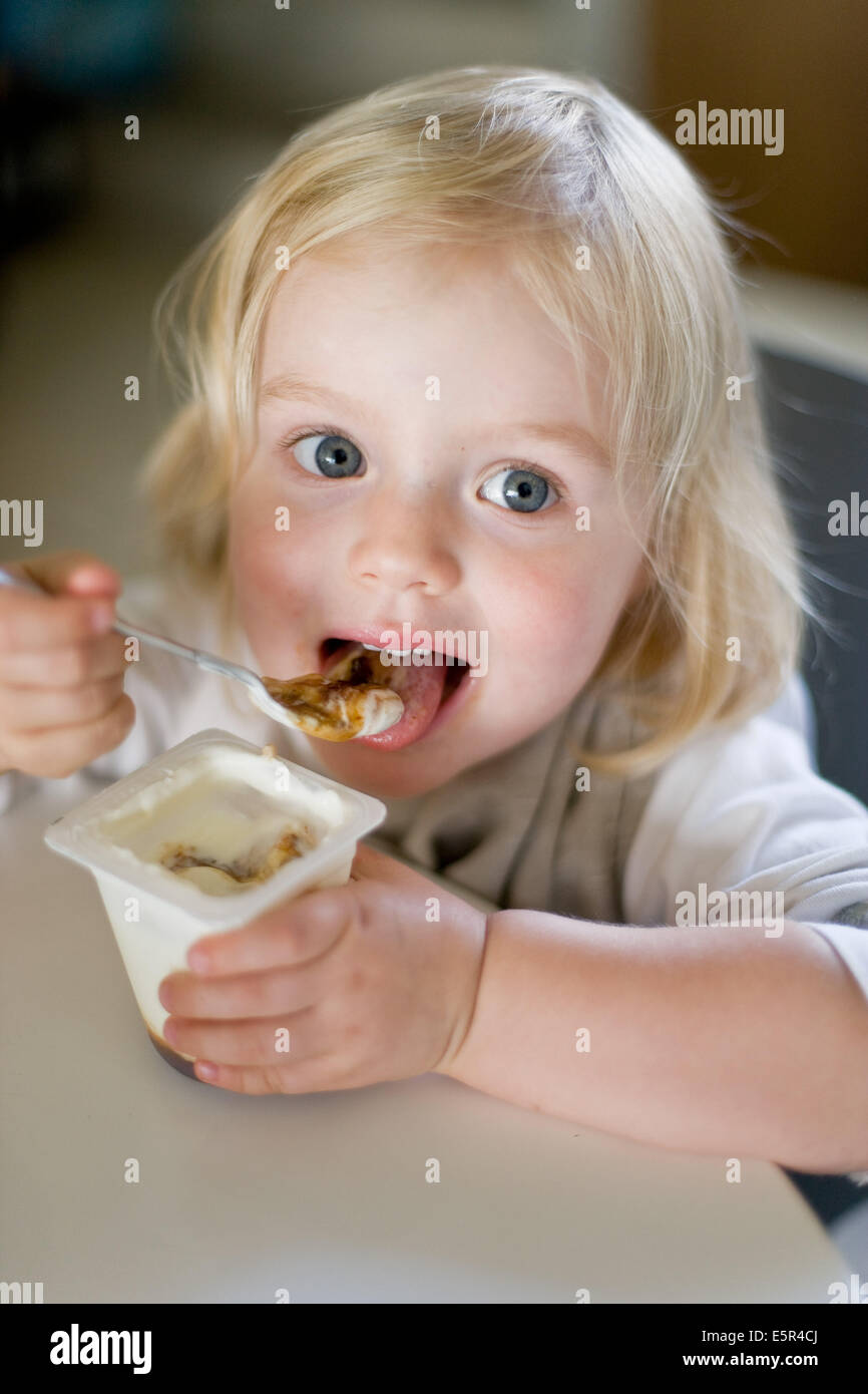 30 month old girl eating a yogurt Stock Photo - Alamy