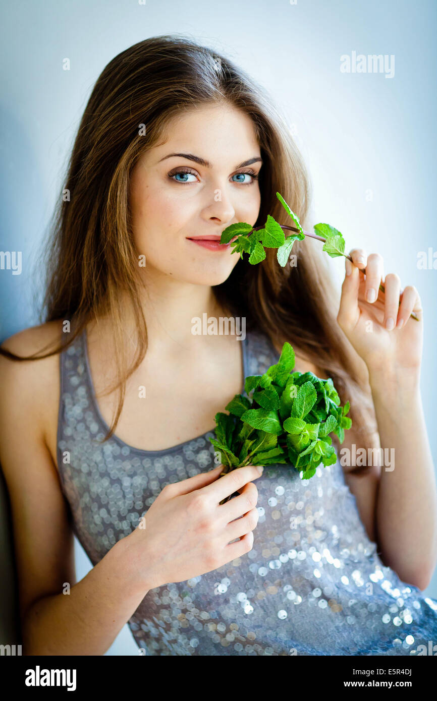 Woman smelling mint leaves (Mentha sp Stock Photo Alamy
