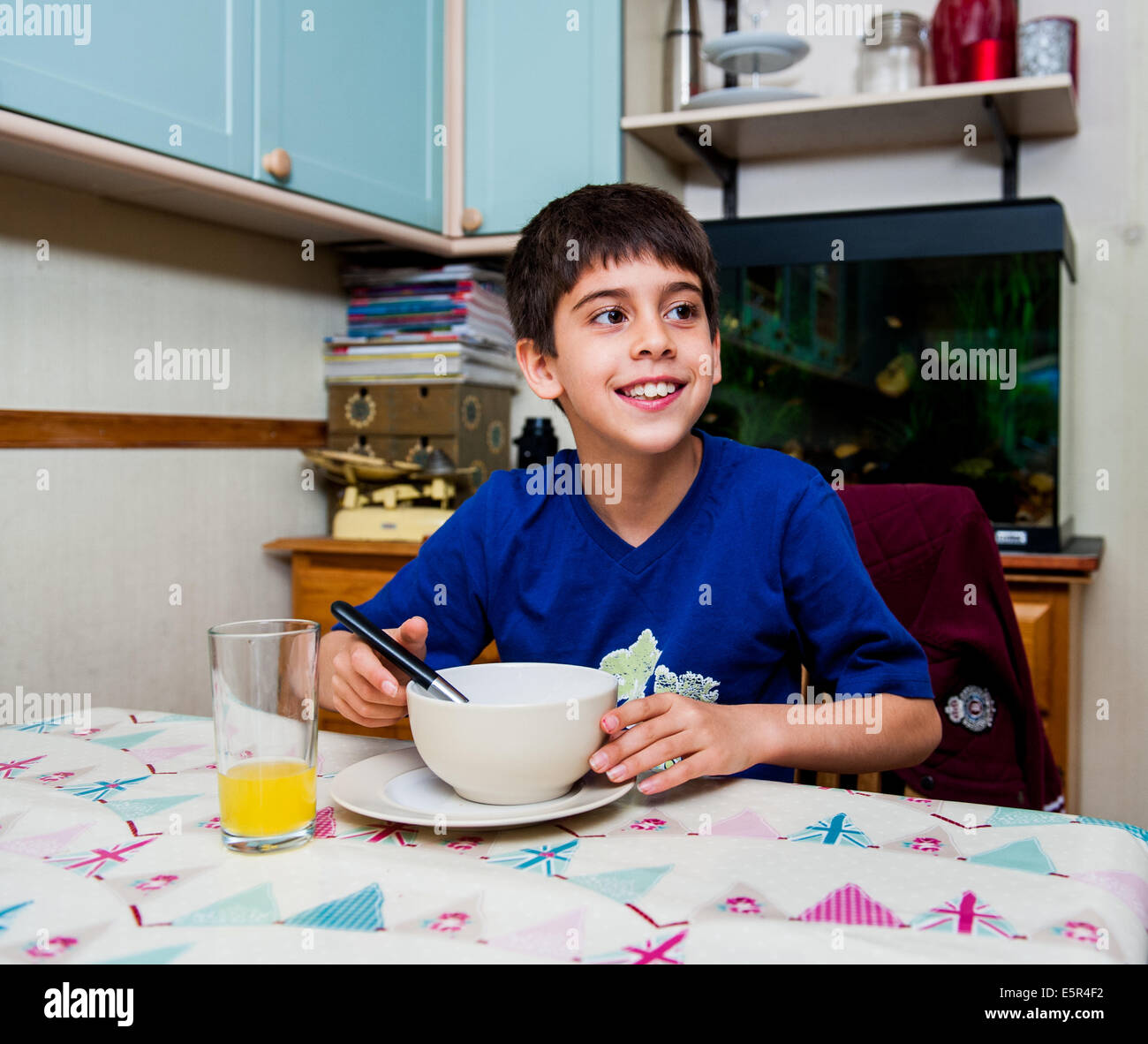 boy 10 11 12 at breakfast eating cereal Stock Photo