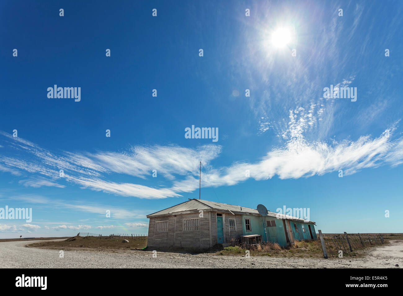Abandoned house by the road, picture against the sun. Stock Photo