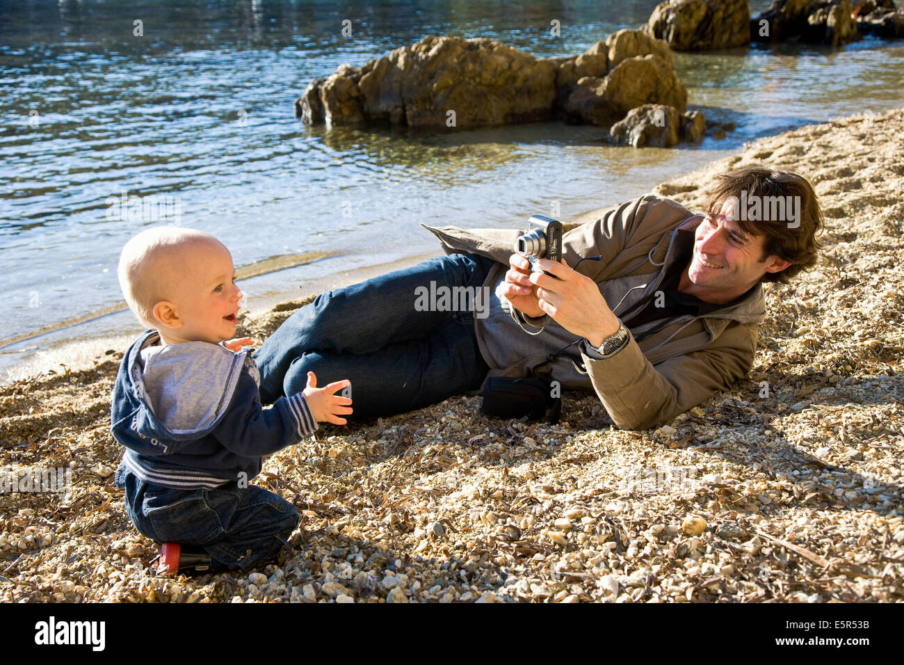 Father taking picture of his one year old baby. Stock Photo