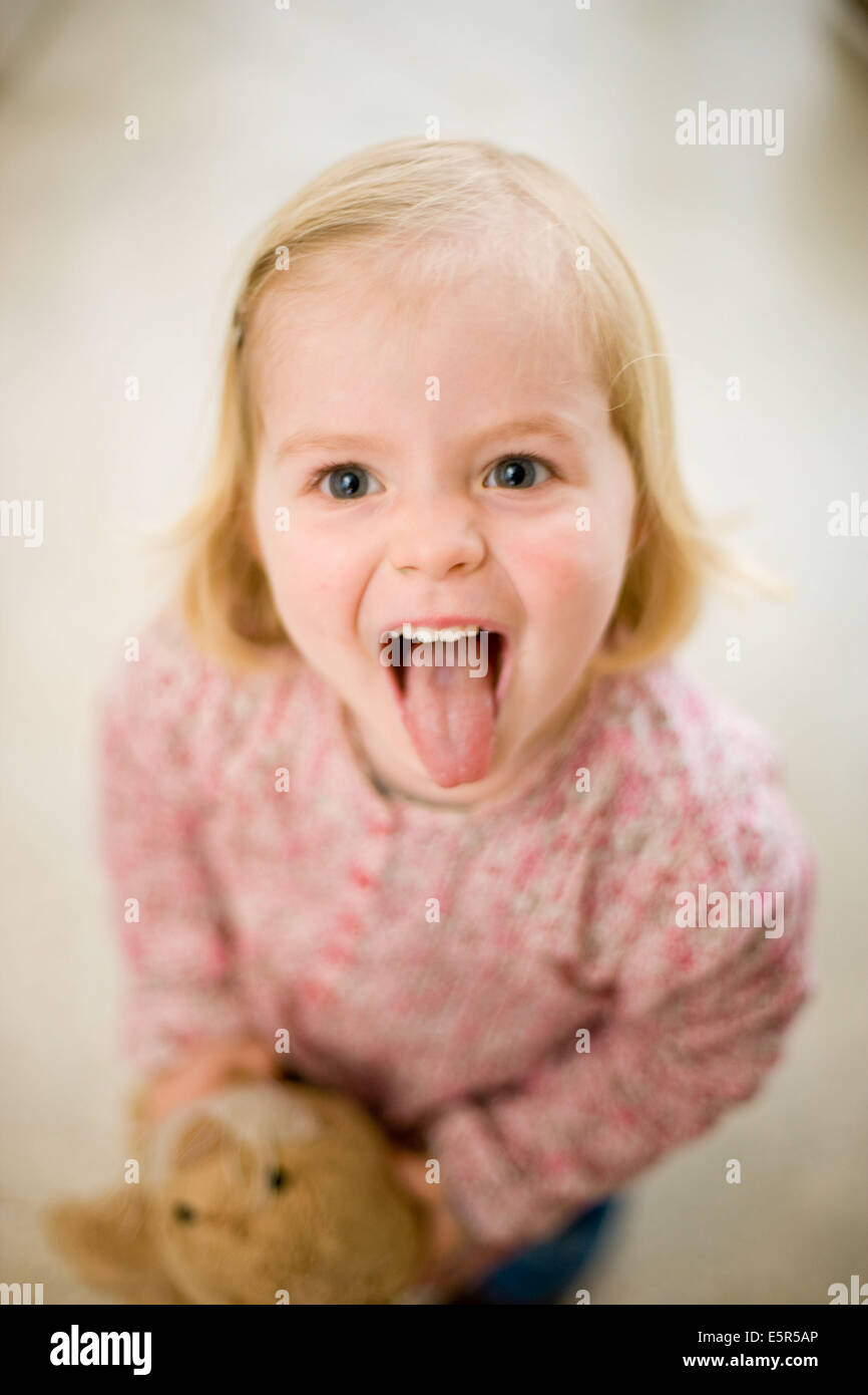 3-year-old girl sticking out her tongue. Stock Photo