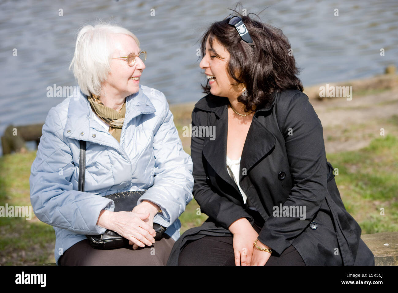 Home care aid talking with elderly woman with Alzheimer's disease. Stock Photo